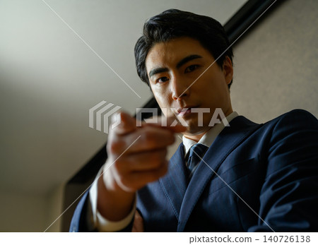 A man in a suit points in this direction. A man in a suit points in this direction. 140726138