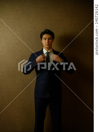 A sharp-looking businessman adjusting his suit. A sharp-looking businessman adjusting his suit. 140726142