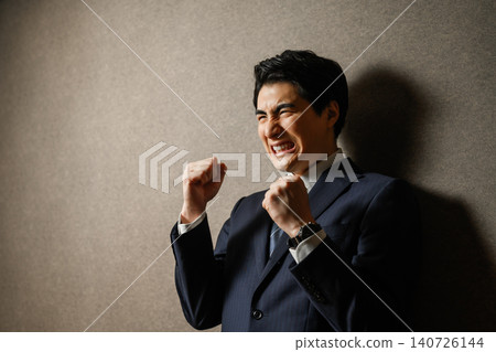 A young businessman makes a powerful fist pump. A young businessman makes a powerful fist pump. 140726144