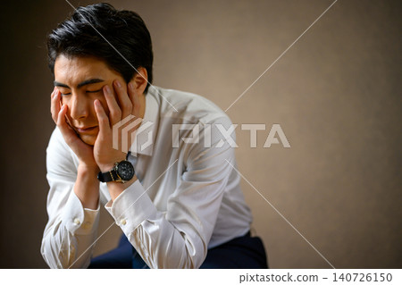 一位商人伏案沉思的側臉。 140726150