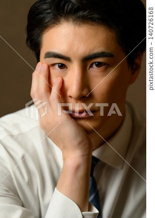 一個穿著西裝的男人,手托著下巴,盯著我看。 一個穿著西裝的男人,手托著下巴,盯著我看。 140726168