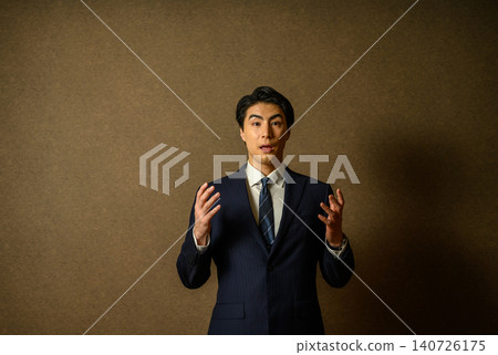 一位身著西裝的商人熱情地解釋。 一位身著西裝的商人熱情地解釋。 140726175