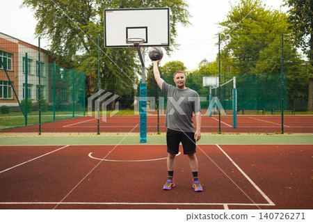 Full shot man holding basketball ball on court 140726271