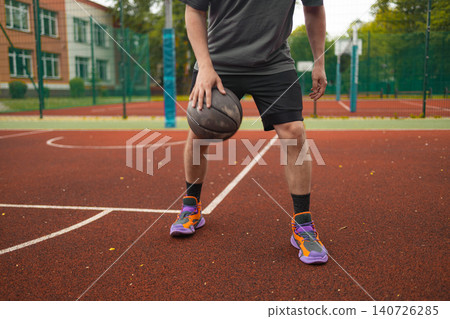 Cropped view of man dribbling basketball on court Cropped view of man dribbling basketball on court 140726285