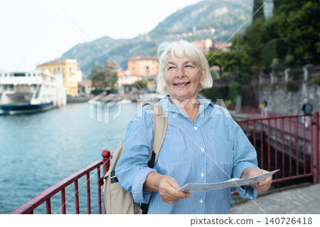 Happy senior woman tourist with a map at Lake Como 140726418