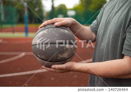 Close up of man holding basketball ball with two hands 140726464