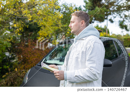 Happy male tourist with map and coffee near car on road trip Happy male tourist with map and coffee near car on road trip 140726467