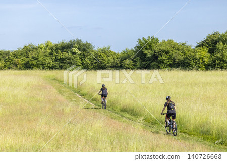 Women mountain biking on a path in nature Women mountain biking on a path in nature 140726668