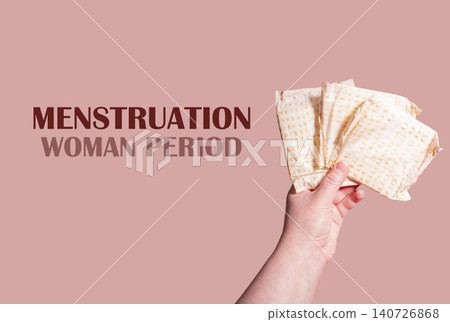 White sanitary pads in hand. Concept of menstruation, ovulation, reproduction, pain and personal feminine hygiene White sanitary pads in hand. Concept of menstruation, ovulation, reproduction, pain and personal feminine hygiene 140726868