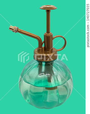Vintage style green glass plant mister with golden plastic pump isolated against solid turquoise background, concept of indoor gardening and plant care Vintage style green glass plant mister with golden plastic pump isolated against solid turquoise background, concept of indoor gardening and plant care 140727035