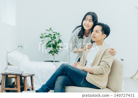 一對年輕夫婦在客廳裡放鬆 140727431