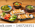 A variety of à la carte dishes, dumplings, and hot pot dishes lined up on the table at the izakaya (Japanese pub) - a platter of banquet menu items. 140728351