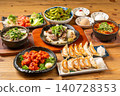 A variety of à la carte dishes, dumplings, and hot pot dishes lined up on the table at the izakaya (Japanese pub) - a platter of banquet menu items. 140728353