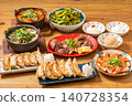 A variety of à la carte dishes, dumplings, and hot pot dishes lined up on the table at the izakaya (Japanese pub) - a platter of banquet menu items. 140728354