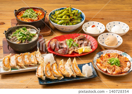 A variety of à la carte dishes, dumplings, and hot pot dishes lined up on the table at the izakaya (Japanese pub) - a platter of banquet menu items. 140728354