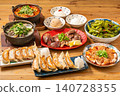 A variety of à la carte dishes, dumplings, and hot pot dishes lined up on the table at the izakaya (Japanese pub) - a platter of banquet menu items. 140728355