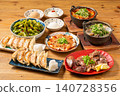 A variety of à la carte dishes, dumplings, and hot pot dishes lined up on the table at the izakaya (Japanese pub) - a platter of banquet menu items. 140728356