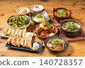 A variety of à la carte dishes, dumplings, and hot pot dishes lined up on the table at the izakaya (Japanese pub) - a platter of banquet menu items. 140728357