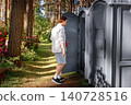 Man opening a grey outdoor portable toilet restroom in a nature park. Concept of an urgent toilet emergency, diarrhea, and digestive stomach discomfort. 140728516