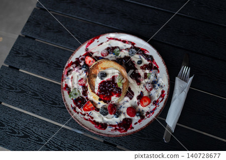 Traditional cottage cheese pancakes syrniki with sour cream and berries close up Traditional cottage cheese pancakes syrniki with sour cream and berries close up 140728677