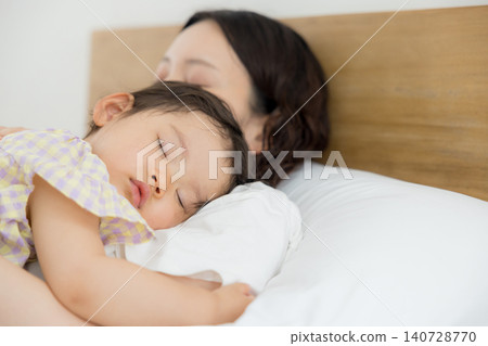 一位母親抱著她一歲的女兒。 一位母親抱著她一歲的女兒。 140728770