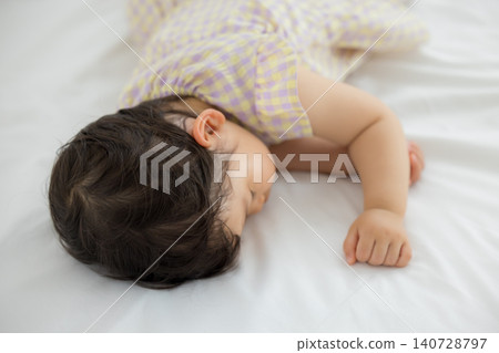 A one-year-old girl taking a nap A one-year-old girl taking a nap 140728797