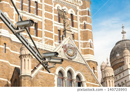 Mumbai Maharashtra India Jan 18 2026 Modern white CCTV surveillance cameras mounted on a metal arm overlooking the historic facade and ornate carvings of the BMC building. Mumbai Maharashtra India Jan 18 2026 Modern white CCTV surveillance cameras mounted on a metal arm overlooking the historic facade and ornate carvings of the BMC building. 140728993