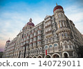 Mumbai Maharashtra India Jan 18 2026 Ornate red domes and grey stone architectural details of the historic Taj Mahal Palace Hotel building against a bright blue sky in South Mumbai 140729011