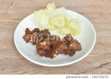 fried fermenting pork cartilage bone with garlic with iceburg lettuce salad on plate 140729233