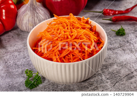 Spicy Korean carrot salad in white bowl with garlic and chili peppers Spicy Korean carrot salad in white bowl with garlic and chili peppers 140729904