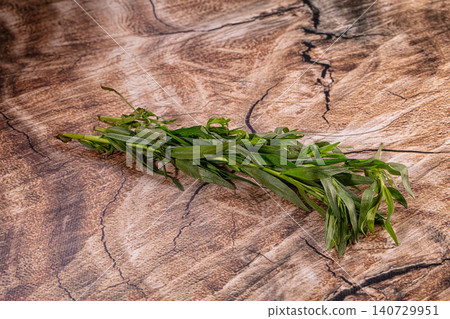 Fresh green tarragon bunch on rustic wooden background Fresh green tarragon bunch on rustic wooden background 140729951