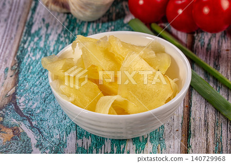 Pickled ginger in white bowl with fresh vegetables on rustic wooden table Pickled ginger in white bowl with fresh vegetables on rustic wooden table 140729968
