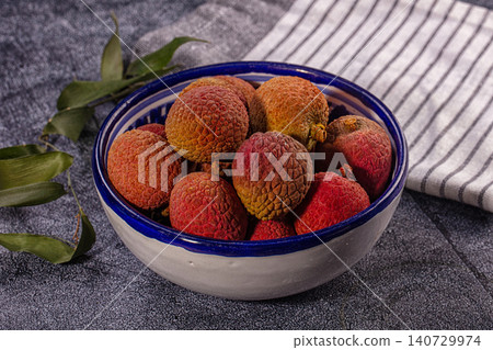 Ripe lychee fruits in blue and white ceramic bowl on dark background Ripe lychee fruits in blue and white ceramic bowl on dark background 140729974