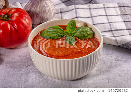 Fresh gazpacho soup in white bowl with basil and tomato ingredients on stone surface Fresh gazpacho soup in white bowl with basil and tomato ingredients on stone surface 140729982