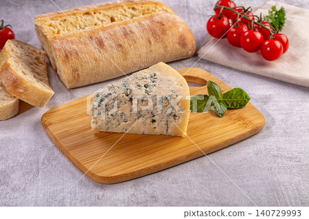 Blue cheese wedge with bread and tomatoes on wooden board 140729993