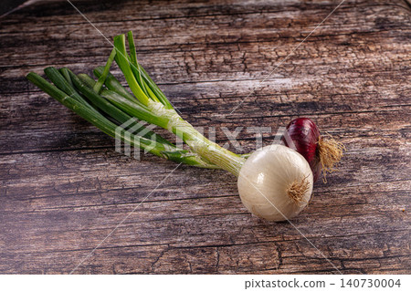 Fresh green onions white and red onions on rustic wooden background Fresh green onions white and red onions on rustic wooden background 140730004