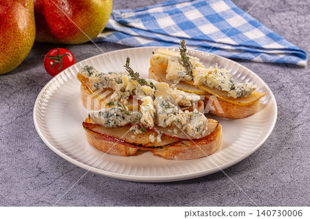 Bruschetta with caramelized pears and blue cheese on white plate Bruschetta with caramelized pears and blue cheese on white plate 140730006