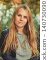 Content young woman with long blonde hair and green eyes outdoors 140730090
