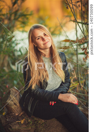Portrait of smiling young woman in black leather jacket enjoying autumn nature Portrait of smiling young woman in black leather jacket enjoying autumn nature 140730099