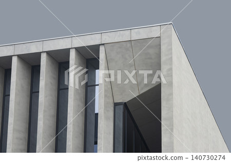 Concrete building facade with deep vertical columns and geometric shadows. Modern structure emphasizes strong architectural rhythm and form. Concept of minimalist design exterior detail.. Concrete building facade with deep vertical columns and geometric shadows. Modern structure emphasizes strong architectural rhythm and form. Concept of minimalist design exterior detail.. 140730274