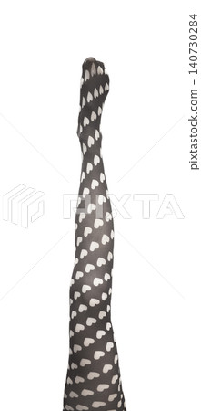 Female legs in heart pattern tights isolated white background. Stylish hosiery with playful print shown in minimal composition. Concept of fashion clothing design.. Female legs in heart pattern tights isolated white background. Stylish hosiery with playful print shown in minimal composition. Concept of fashion clothing design.. 140730284