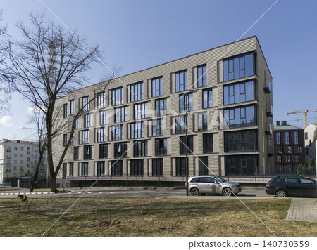 Modern residential building with extended facade and geometric layout in urban area. Apartment structure shows linear composition and clean design. Concept of contemporary housing Modern residential building with extended facade and geometric layout in urban area. Apartment structure shows linear composition and clean design. Concept of contemporary housing 140730359
