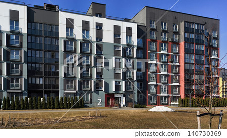 Modern residential buildings with contrasting facade colors and geometric layout. Apartment structures create urban composition with clean lines. Concept of contemporary housing development Modern residential buildings with contrasting facade colors and geometric layout. Apartment structures create urban composition with clean lines. Concept of contemporary housing development 140730369