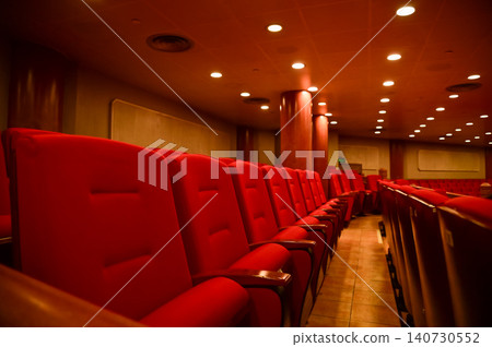 Close up of red theatre chair. Empty red seats in the theatre. Patterns of chairs in a theater. Seats background pattern photo.  140730552