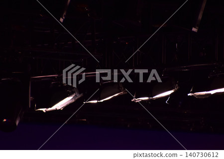Set of professional stage lighting equipment on the stage for gig illumination of theater or concert hall. Stage lights, spotlights and laser beams. Rays of light from the floodlights. Concert light. Set of professional stage lighting equipment on the stage for gig illumination of theater or concert hall. Stage lights, spotlights and laser beams. Rays of light from the floodlights. Concert light. 140730612