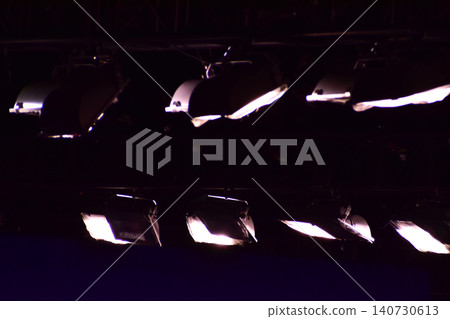Set of professional stage lighting equipment on the stage for gig illumination of theater or concert hall. Stage lights, spotlights and laser beams. Rays of light from the floodlights. Concert light. Set of professional stage lighting equipment on the stage for gig illumination of theater or concert hall. Stage lights, spotlights and laser beams. Rays of light from the floodlights. Concert light. 140730613