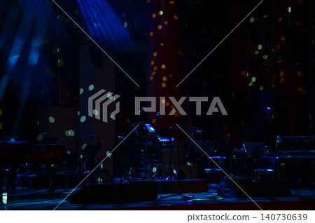A set of musical instruments on an empty stage of the theater, lit by spotlights, before the performance. Stage before concert. A set of musical instruments on an empty stage of the theater, lit by spotlights, before the performance. Stage before concert. 140730639