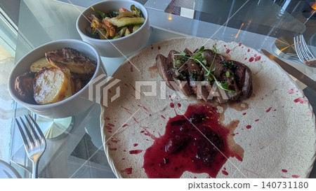 Duck breast fillet with red berry sauce and vegetable side dishes Duck breast fillet with red berry sauce and vegetable side dishes 140731180