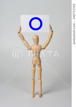 A drawing mannequin holding a placard with a blue circle (〇) on it. A drawing mannequin holding a placard with a blue circle (〇) on it. 140731591