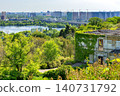 View of city skyline by the river with greenery and old building in the foreground during a sunny day 140731792